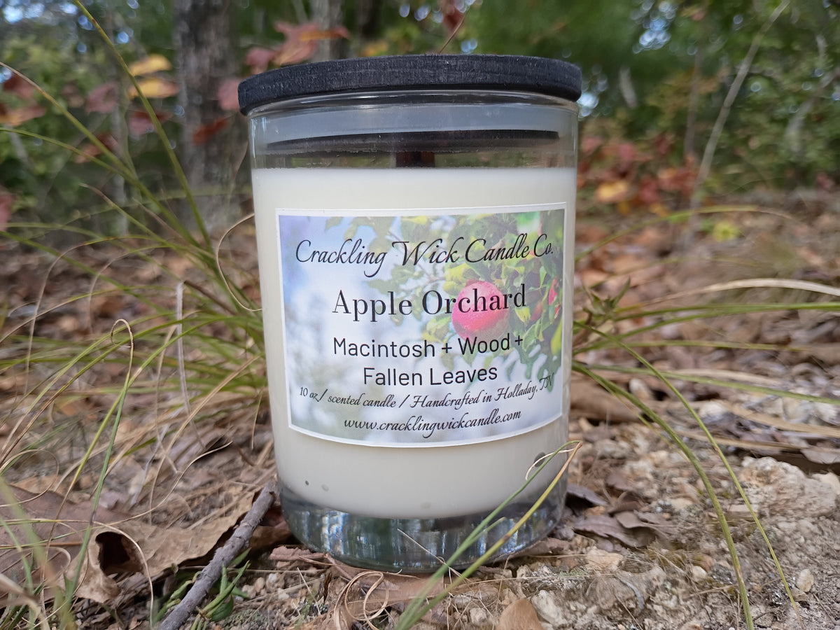 Glass jar candle with white wax; Macintosh, wood, fallen leaves label; black lid