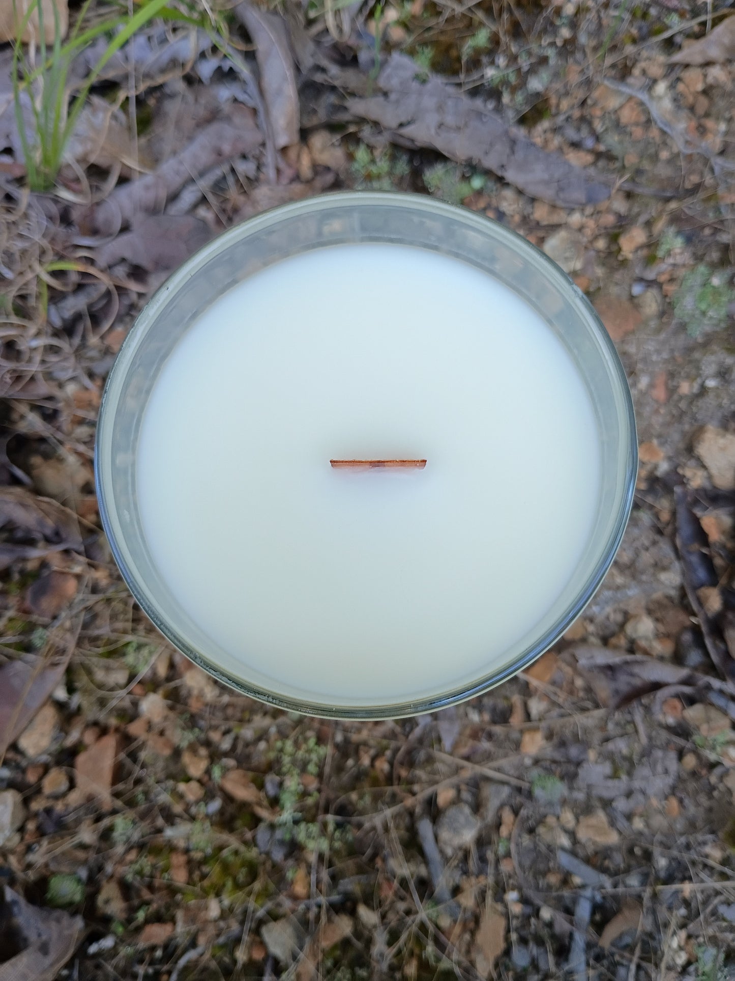 Clear-lidded candle jar with pale blue wax and copper wick tab centered